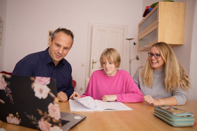 Família auxiliando a filha na tarefa escolar